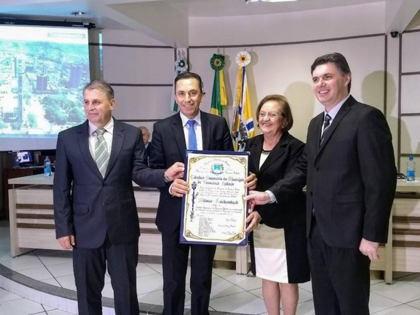  Reichembach recebendo o título de Cidadão Honorário de Francisco Beltrão das mãos do propositor do projeto, Ivanir Tupi Prolo, da presidente da Câmara de Vereadores, Elenir Maciel, e do prefeito Cleber Fontana.