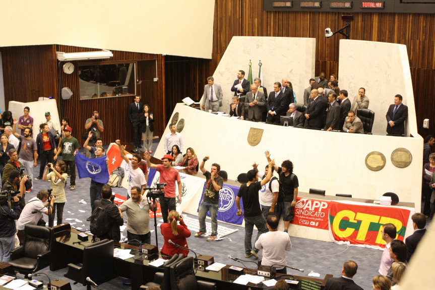 Após invasão do Plenário, manifestantes rasgam pautas de votações e demais documentos que estavam nas bancadas dos deputados.