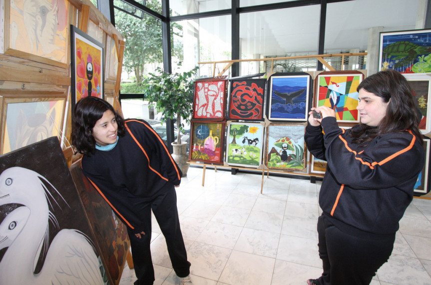 Alunas da Apae de Nova Aurora tiram fotos da exposição dos quadros (Foto: Nani Gois) 