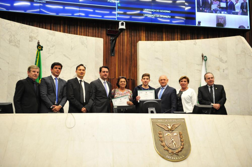 Um dos vencedores do Geração Atitude 2018, João Pedro e sua professora Mara Garófalo recebem a premiação do presidente Ademar Traiano (PSDB), ao lado do governador eleito Ratinho Junior (PSD) e deputados presentes.