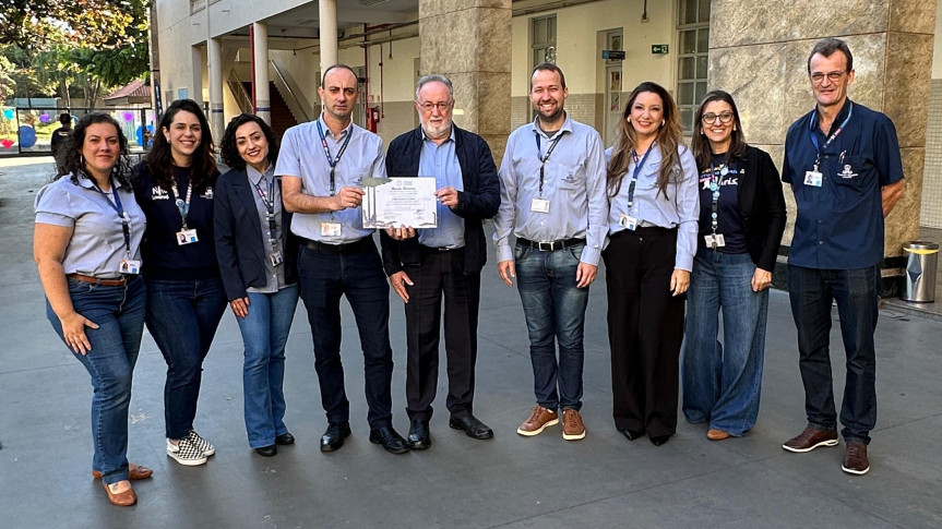 Deputado Tercilio Turini entrega Menção Honrosa da Assembleia ao diretor Adriano Brollo, ao lado de coordenadores, pela excelência na educação, formação de líderes e preparação para a vida.