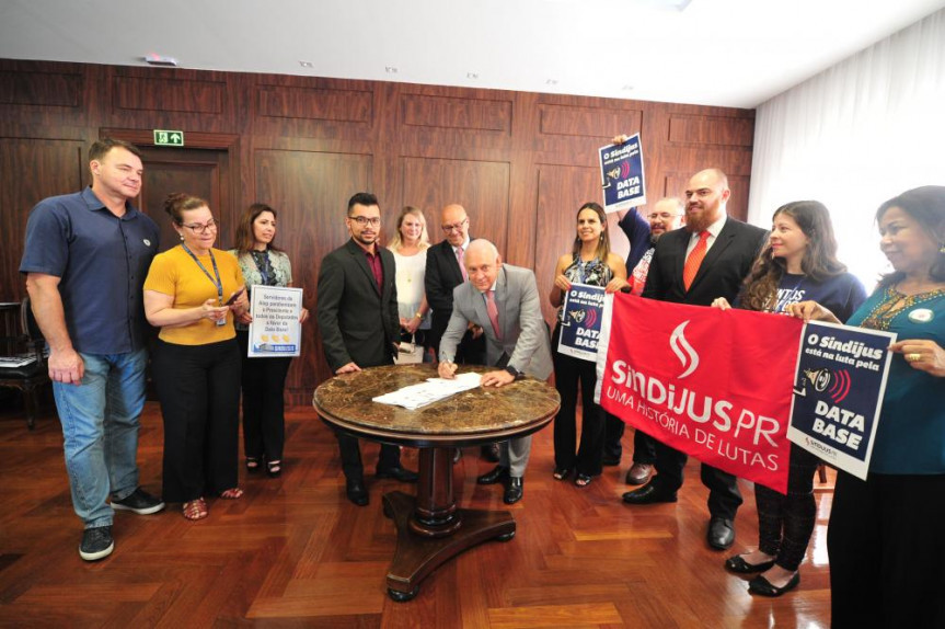 Presidente da Alep, Ademar Traiano, acompanhado do primeiro-secretário, Romanelli, e dirigentes de sindicatos, promulga a lei que reajusta o vencimentos dos servidores da Alep, TJ, TC, MP e Defensoria Pública.