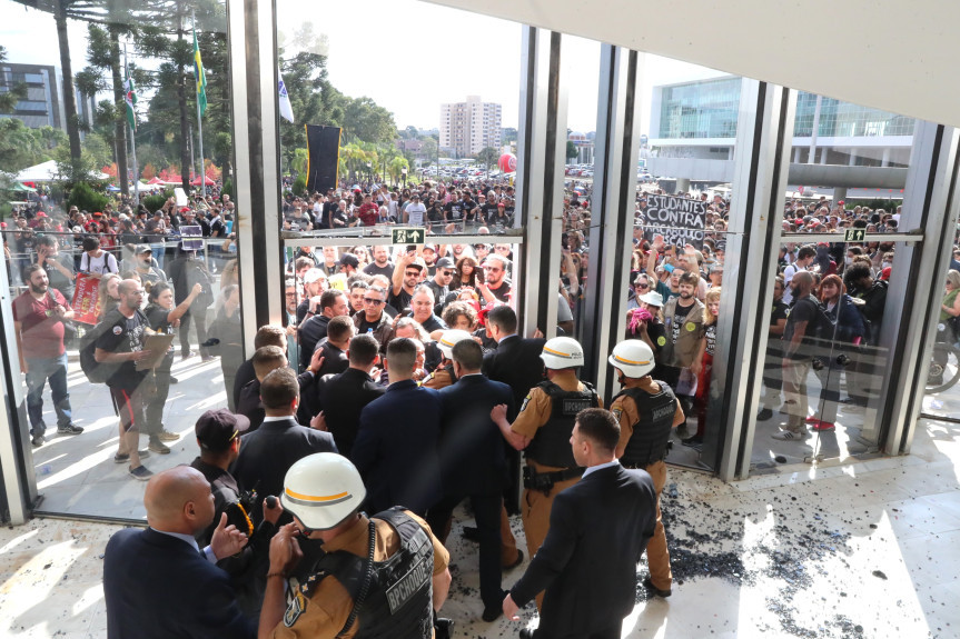 Minutos antes das 14h30, horário regimental da sessão, os manifestantes já estavam nas galerias quando a multidão forçou a entrada, rompendo o portão de acesso a carros da Assembleia e, em seguida, invadindo o Prédio do Plenário.